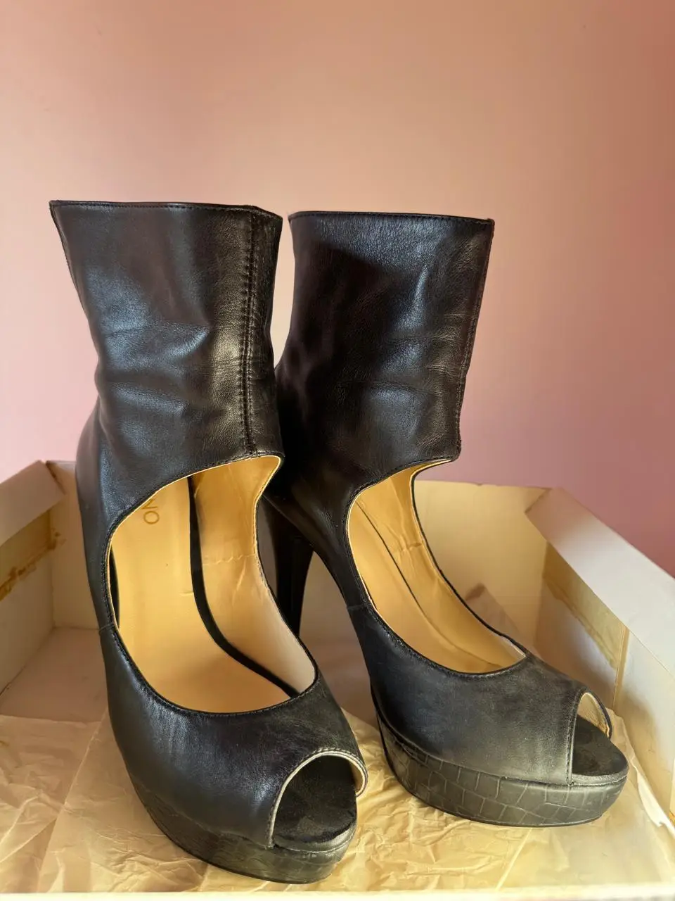 Botas de caña alta negras con plataforma y taco alto. Diseño con abertura lateral y puntera abierta. Ideales para un look sofisticado y moderno.