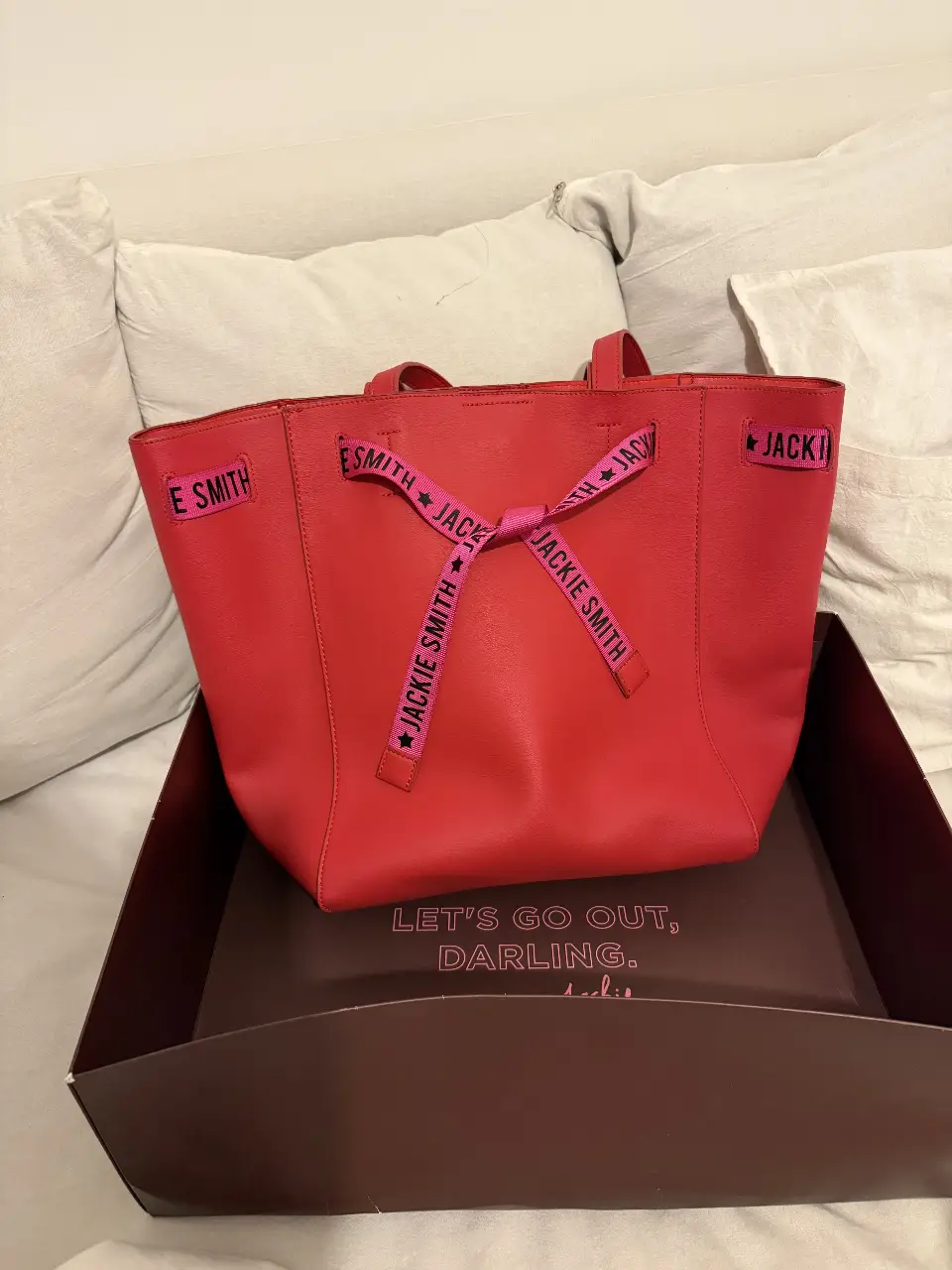 Cartera  tote Jackie Smith roja de cuero con detalles en rosa. Ideal para llevar todo lo necesario con estilo y un toque de color.