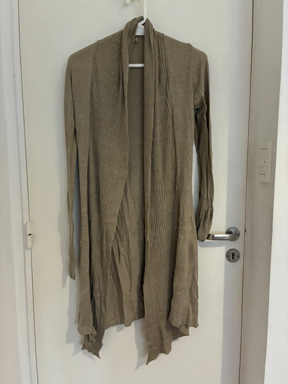 Cardigan largo de tejido fino, con mangas largas y un diseño abierto al frente con solapas. Ideal para un look casual y cómodo.