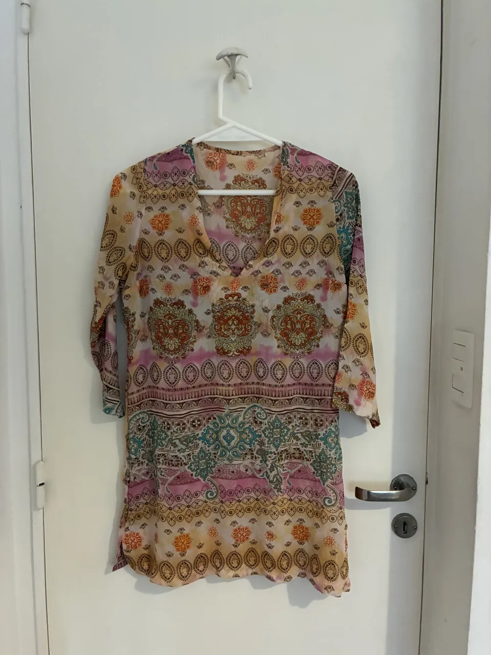 Vestido playero o túnica con estampa vibrante y colorida. Ideal para usar sobre la bikini o como prenda casual en días de calor. Manga larga y escote en V.