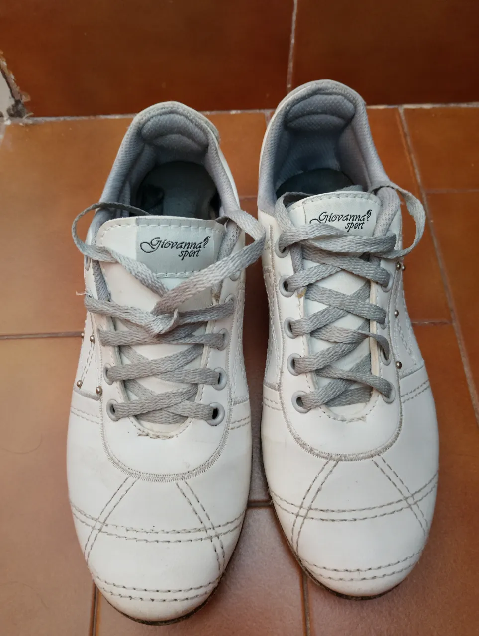 Zapatillas blancas de cuero con cordones grises de algodón y detalles de costuras. Tienen el logo 'Giovanna sport' en la lengüeta.  talle 36 