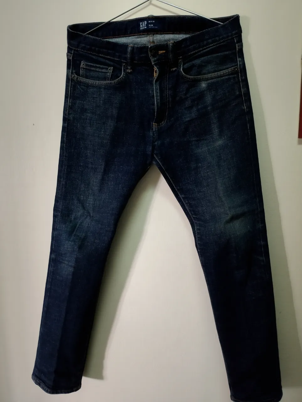 Jeans de corte slim, color azul oscuro, con un lavado que le da un toque moderno y canchero. Perfectos para el día a día, combinan con todo.