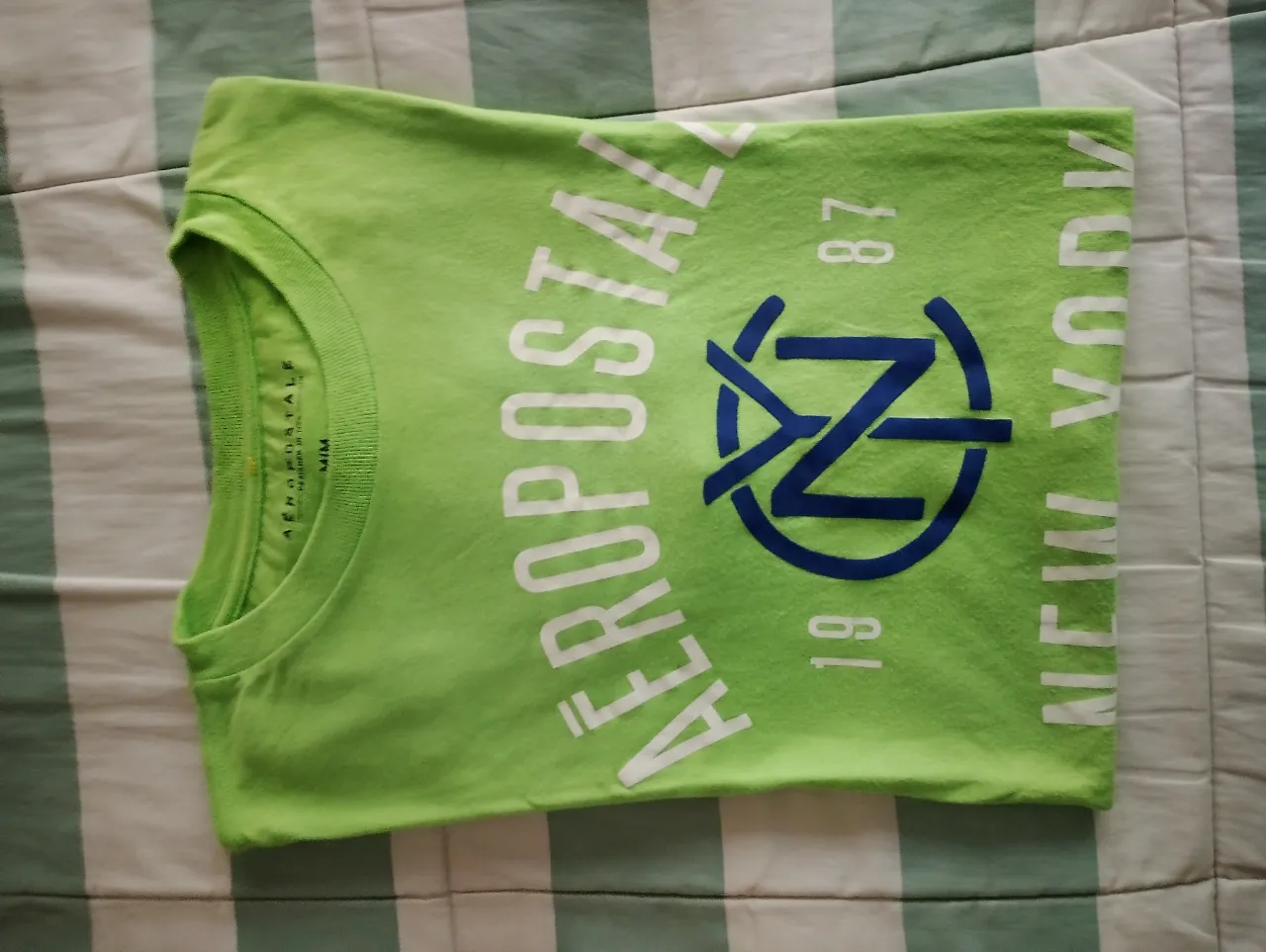 Remera verde lima de manga corta con estampa de "AEROPOSTALE NEW YORK" en blanco y azul. Ideal para un look casual y urbano.