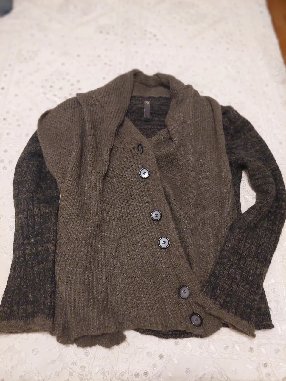 Sweater de tejido rústico con mangas largas y botones al frente. Diseño cruzado y cuello amplio que se puede usar abierto o cerrado. Ideal para un look canchero y abrigado.