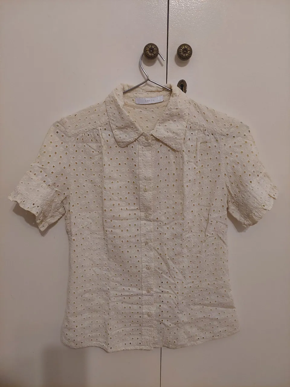 Blusa de broderie color amarillo mantequilla de manga corta y cuello redondo. Las mangas tiene diseños con 2 botones. Perfecta para un look fresco y delicado.