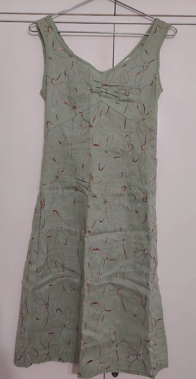 Vestido de verano color verde claro con un delicado estampado floral bordado en tonos tierra. Diseño sin mangas y escote en V, ideal para lucir fresca y elegante en días cálidos. Perfecto para salidas casuales o eventos diurnos.