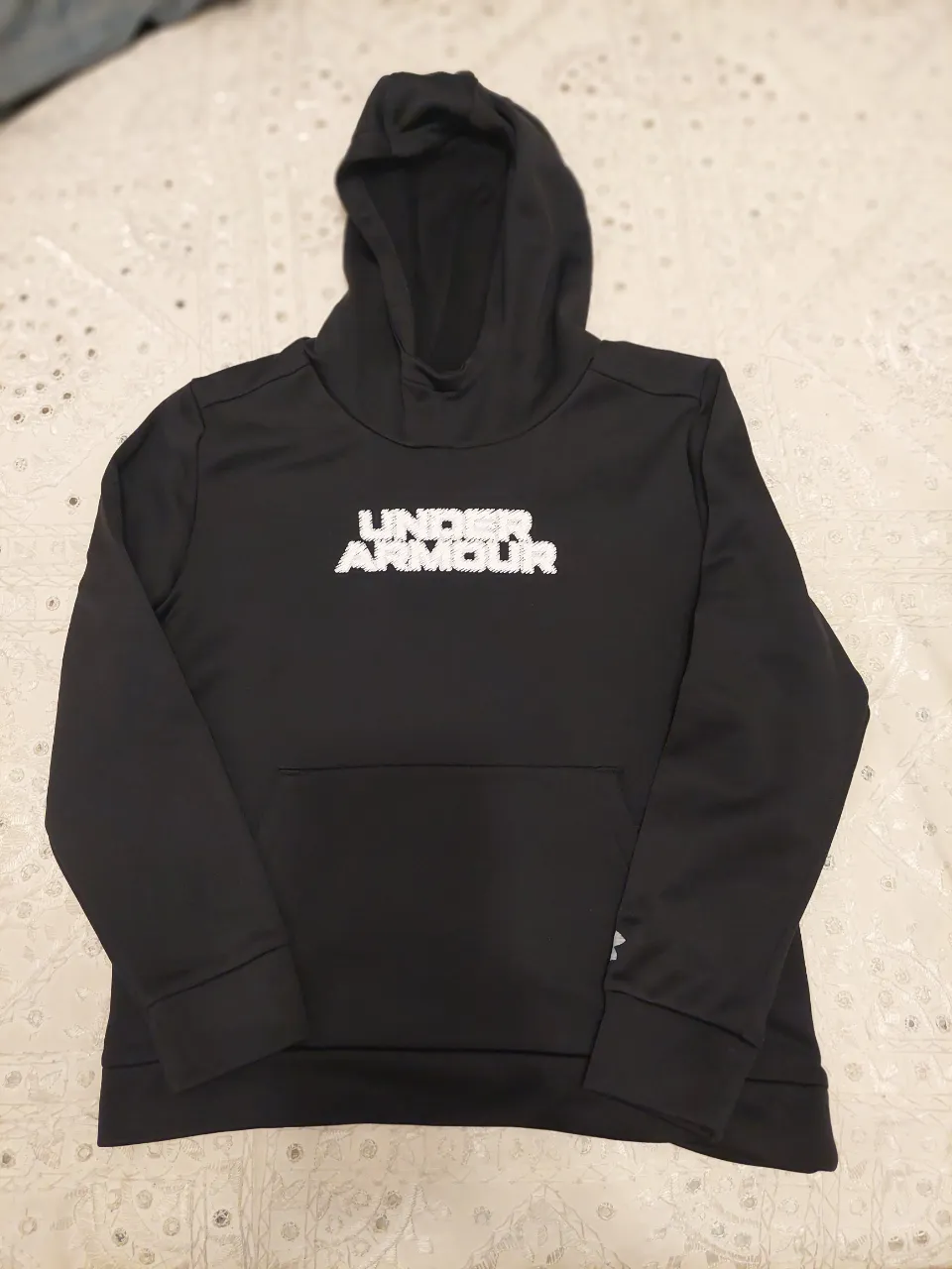 Buzo negro con capucha y logo de Under Armour en el frente. Ideal para entrenamientos o uso diario.