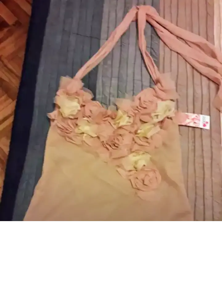 Top de mujer de tul forrado con detalle de flores en el frente.  Con breteles para sujetar al cuello. Ideal para una salida o evento especial. Talle M.