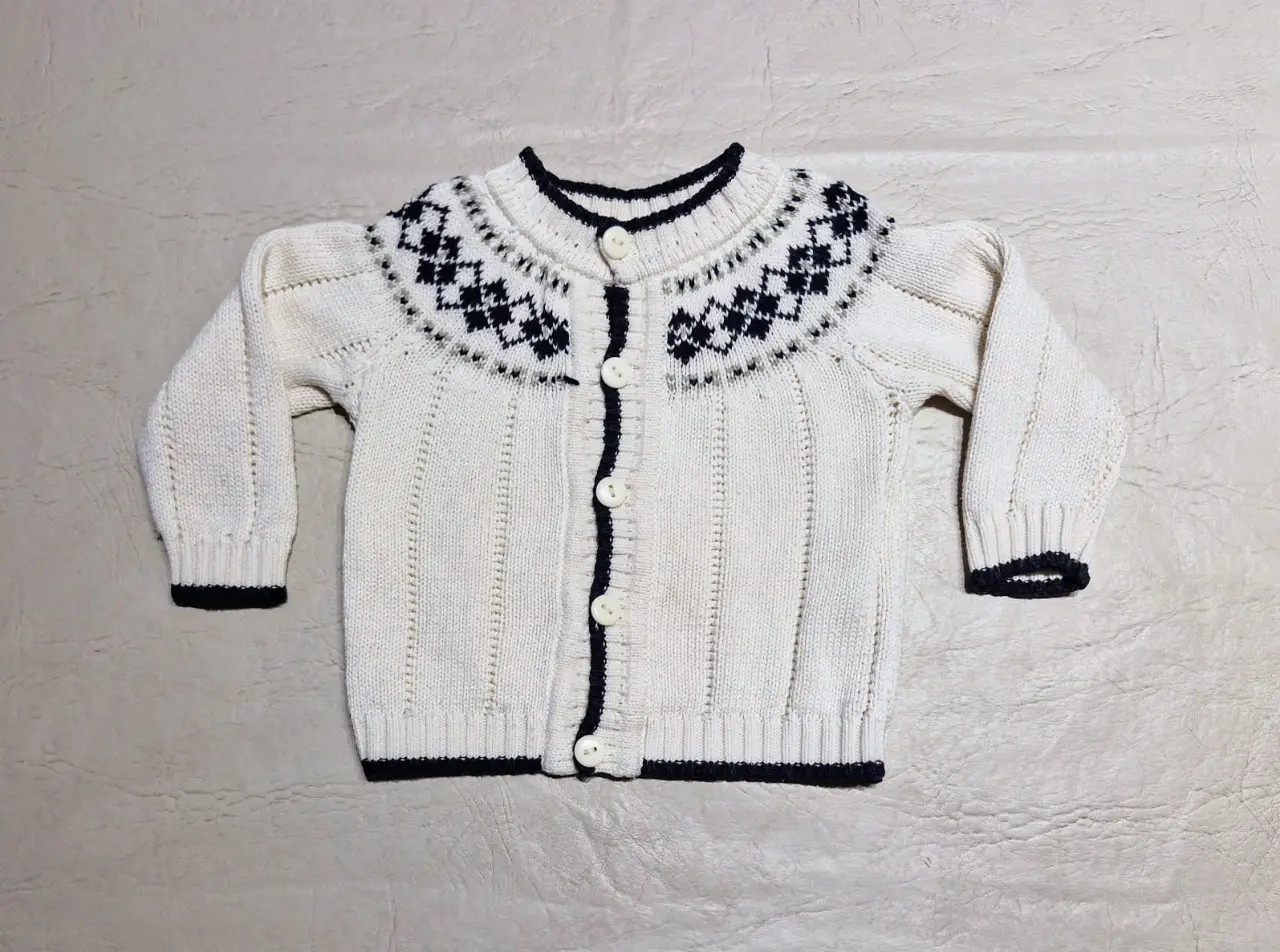 Precioso cardigan de punto para bebé, color crudo con diseño nórdico en el canesú en color azul oscuro. Artesanal, tejido en Salta.  Ideal para mantener a tu pequeño abrigado y con estilo.