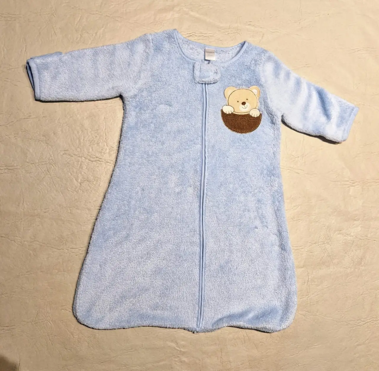 Enterito para bebé de color celeste, con cierre frontal y detalle de oso en el pecho. Ideal para mantener a tu bebé abrigado y cómodo durante la noche.