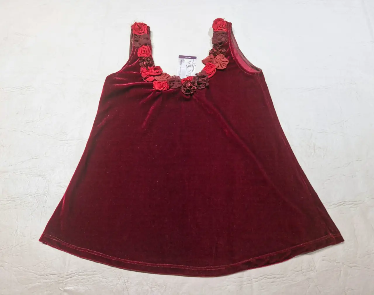 Top de terciopelo bordó con detalles florales en el escote. Ideal para una ocasión especial o para darle un toque elegante a tu look.