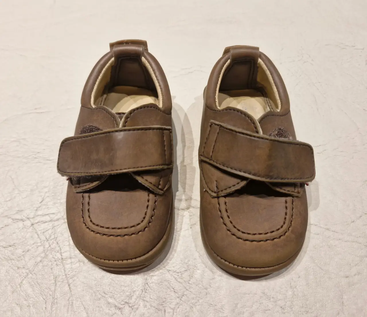 Zapatos de bebé color marrón con cierre de velcro. Ideales para los primeros pasos.