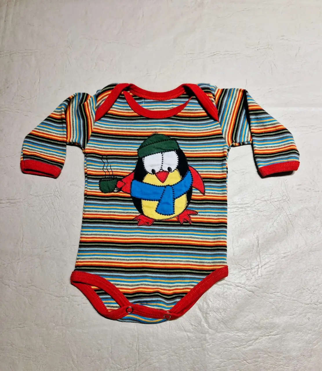 Body de bebé manga larga a rayas con estampado de pingüino con gorro y bufanda. Ideal para mantener a tu bebé abrigado y a la moda.