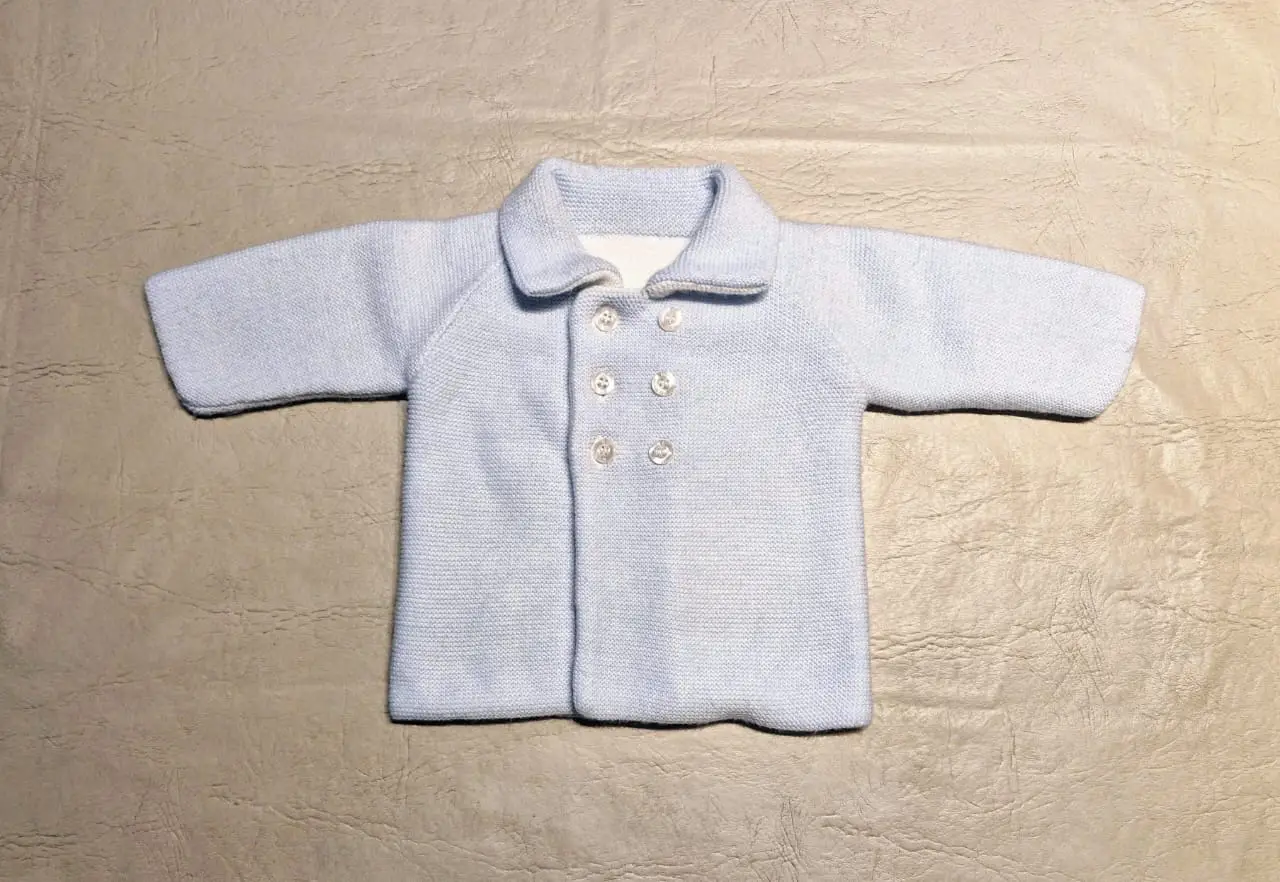 Sacón de bebé de punto santa clara. Reversible, permite usarse del lado  celeste o del lado blanco. Con cuello y botones. Ideal para abrigar a tu niño con estilo. Modelo clásico de la marca Magdalena Espósito.