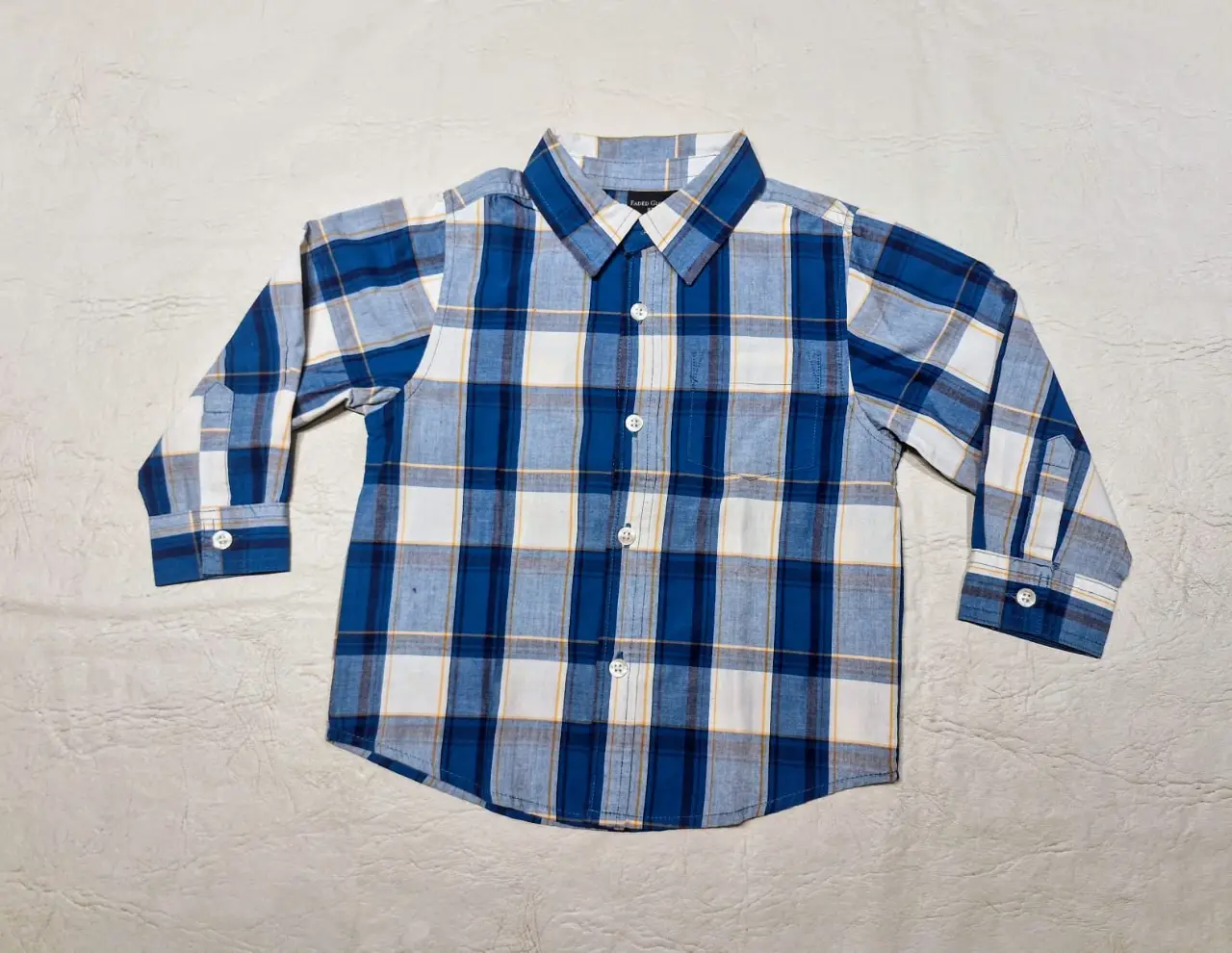 Camisa a cuadros para niño, manga larga, con botones y bolsillo. Ideal para un look casual y cómodo.