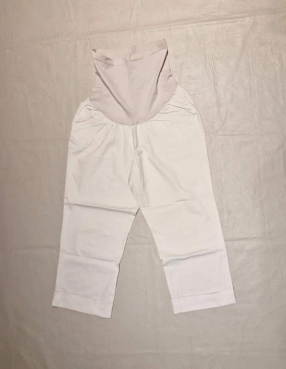 Pantalón premamá blanco, ideal para embarazadas. Corte capri, con tela elástica en la cintura. Diseño cómodo y adaptable, perfecto para el día a día.