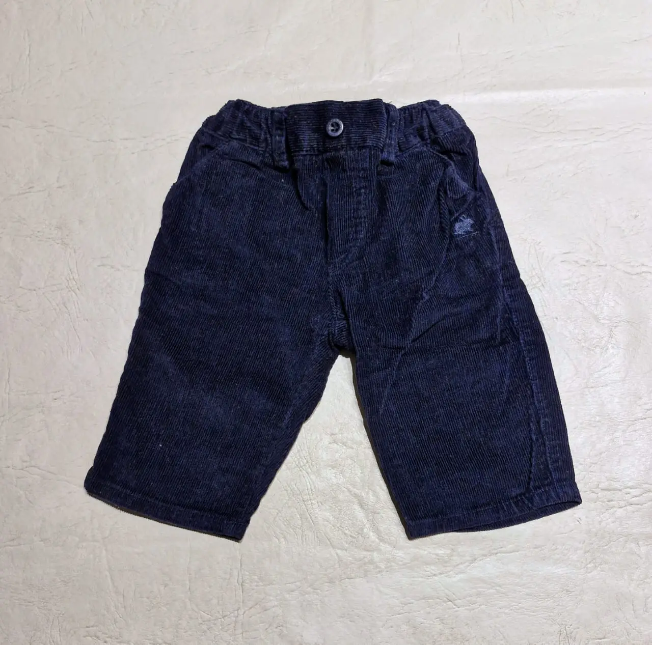 Pantalón de corderoy azul marino para bebé, con dos bolsillos delanteros y dos bolsillos traseros y detalle de la marca Babycottons. Ideal para un look casual y cómodo.