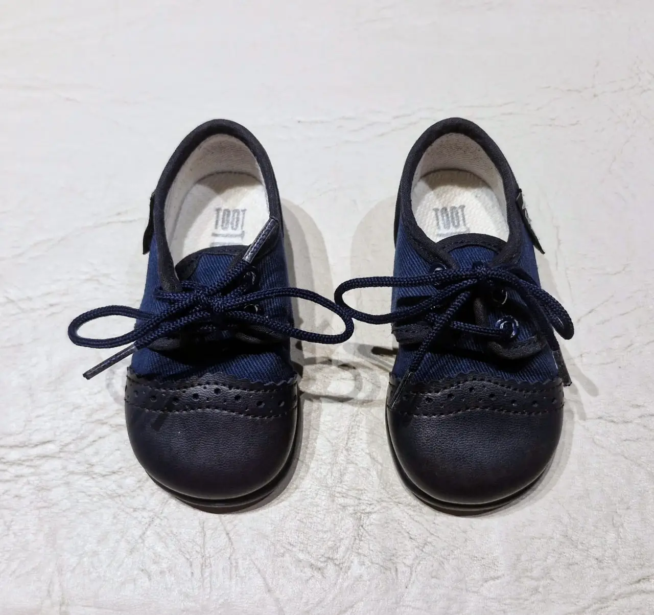 Zapatos de bebé TOOT de tela azules con puntera de cuerina azul más oscuro con cordones. 11 cm. de suela. Ideales para un look formal o casual.