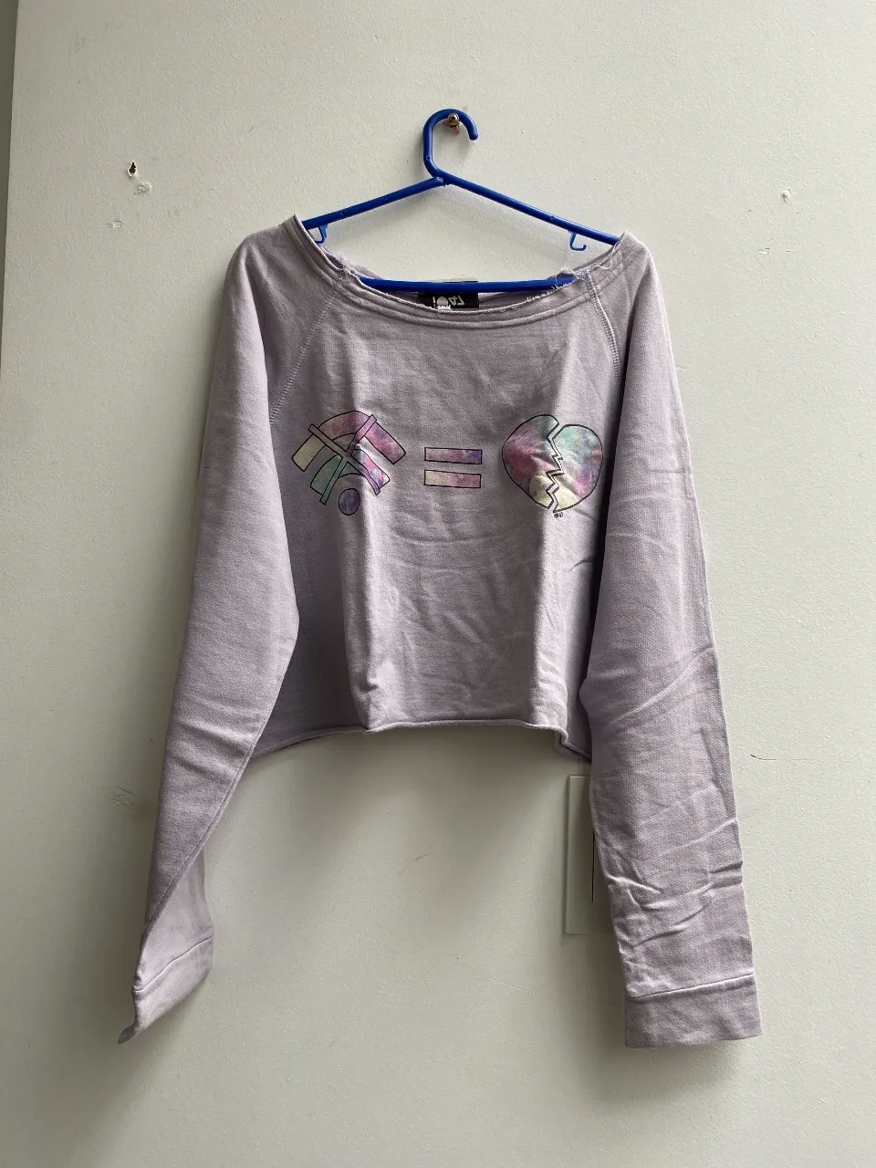 Buzo crop de color lila con estampado de wifi, igual a un corazón roto con detalles en colores pastel. Ideal para un look casual y moderno. talle 2