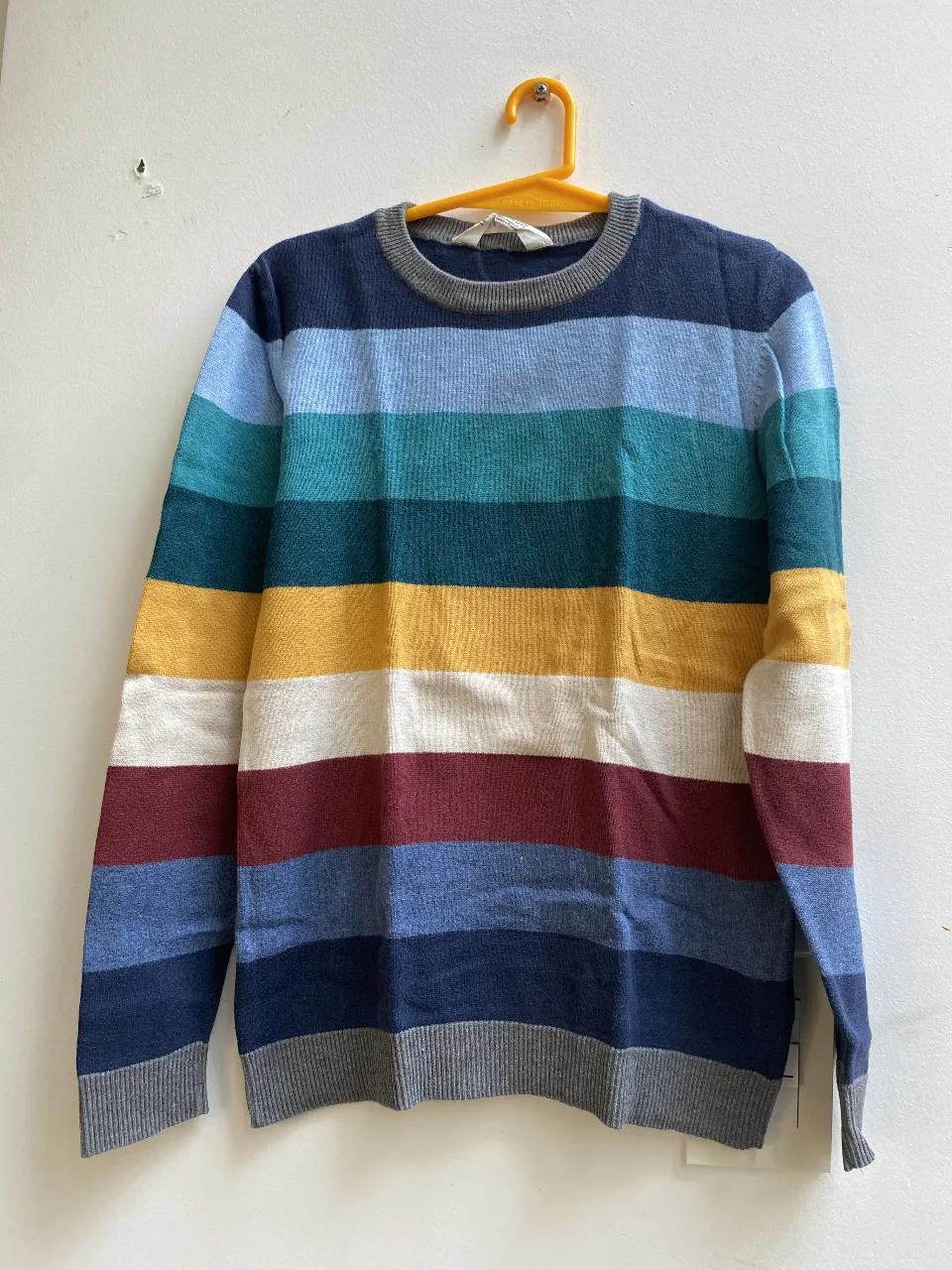 Sweater a rayas multicolor para niño, con cuello redondo y puños grises. Ideal para un look casual y abrigado. Talle 8/10