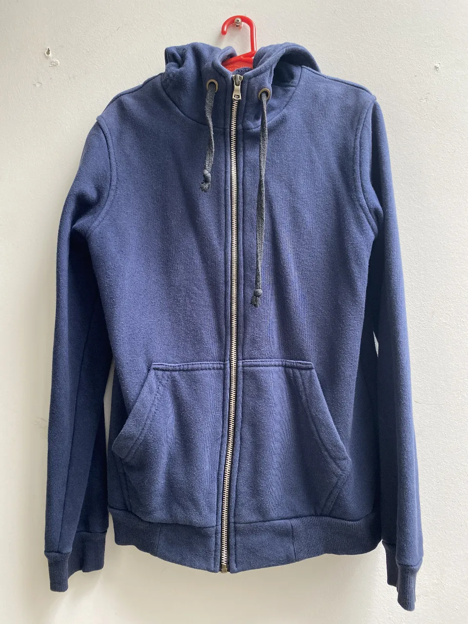 Buzo con cierre azul marino, con capucha y bolsillos delanteros. Ideal para el invierno, cómodo y abrigado. Talle 14