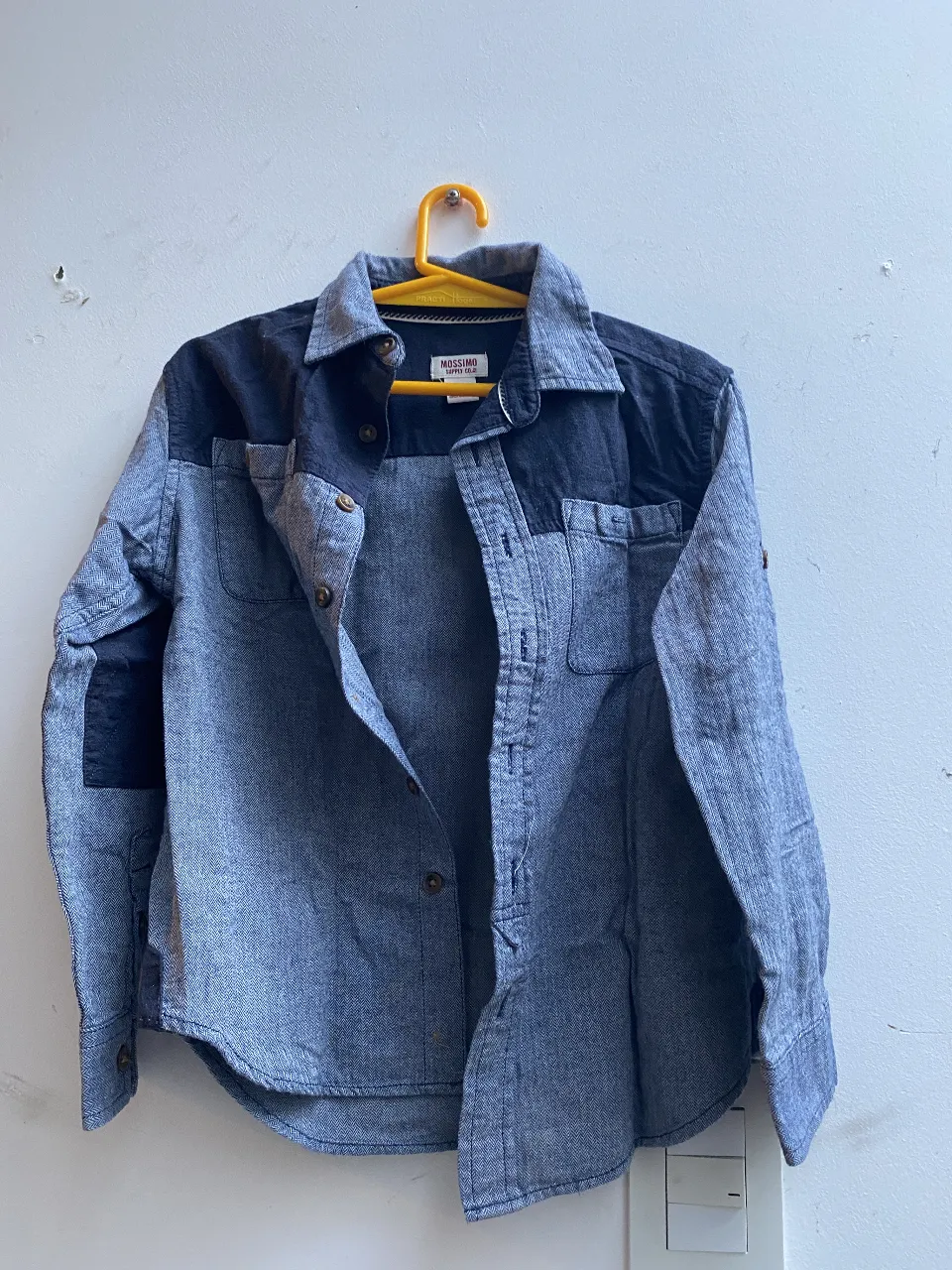 Camisa de hombre Mossimo Supply Co. en denim azul con detalles en negro. Talle 6/7 para niños. Ideal para un look casual y moderno.