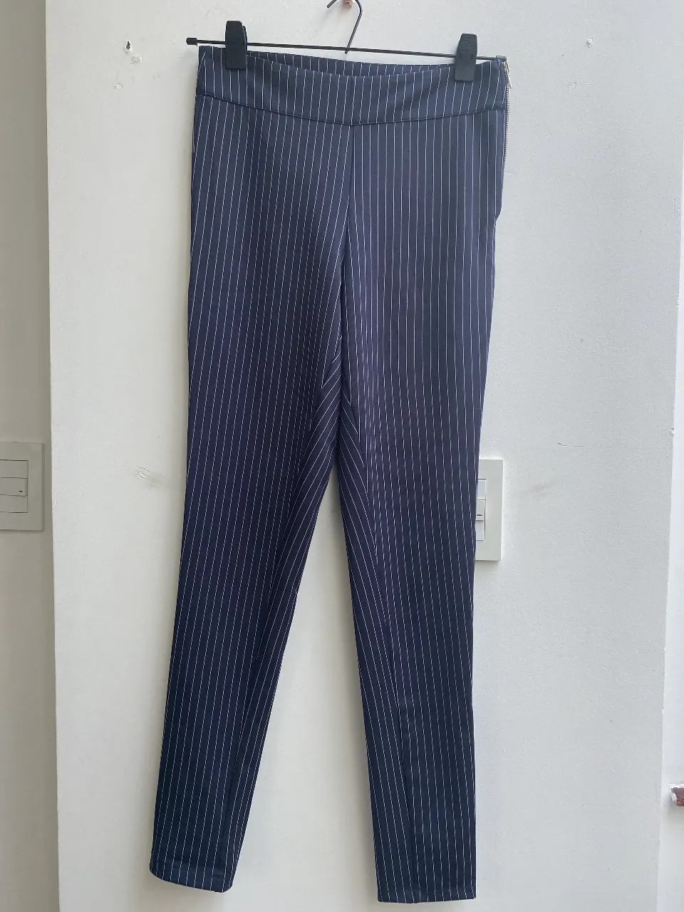 Pantalón sastrero de mujer, azul marino con finas rayas blancas verticales. Tiene cierre lateral y bolsillos traseros. Talle 44. Marca Materia