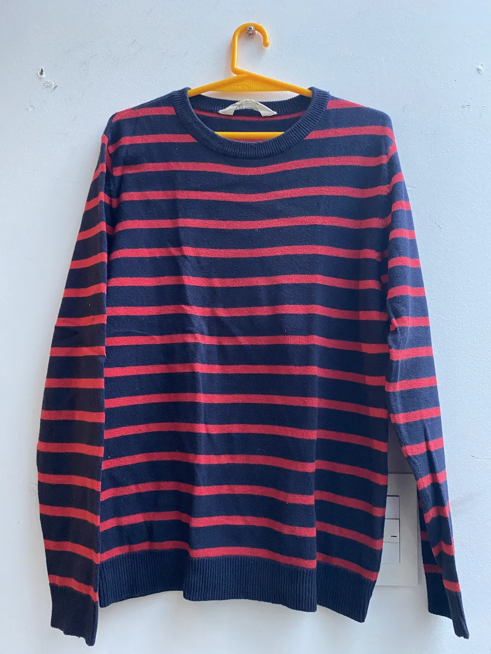 Sweater de hombre a rayas rojas y azules, de la marca H&M. Ideal para un look casual y abrigado.