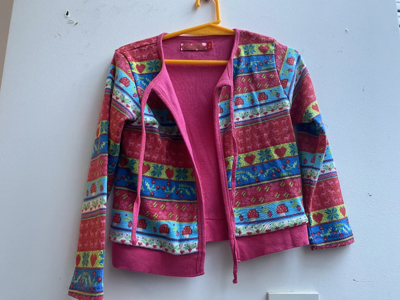 Cardigan de niña con estampado colorido y cierre frontal. Ideal para abrigar con estilo en cualquier ocasión.
