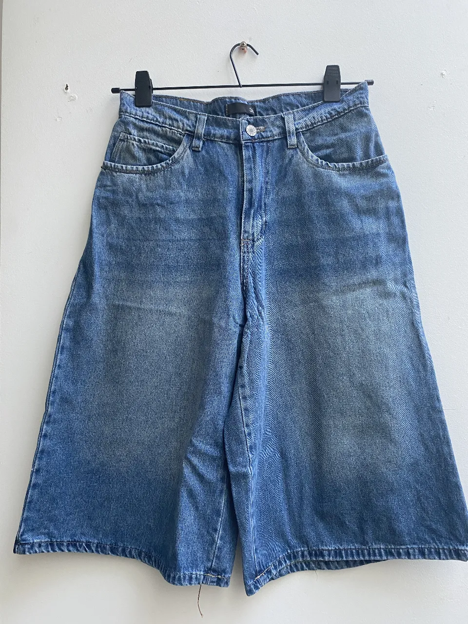 Bernuda larga de jean de corte amplio, con un lavado azul claro. Talle 38. Ideal para un look casual y cómodo.