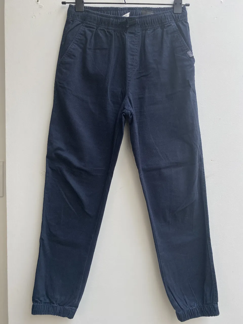 Pantalón jogger de niño, color azul marino, con cintura elastizada y puños en los tobillos. Ideal para un look casual y cómodo. Talle 11/12. Marca H&M