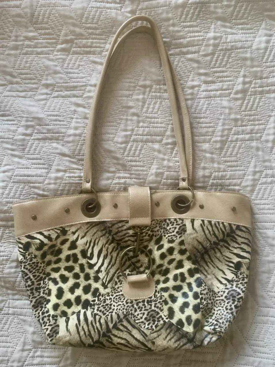 Cartera de hombro con estampado animal print. Diseño con detalles en color crudo y hebilla dorada. Ideal para un look casual y con estilo.