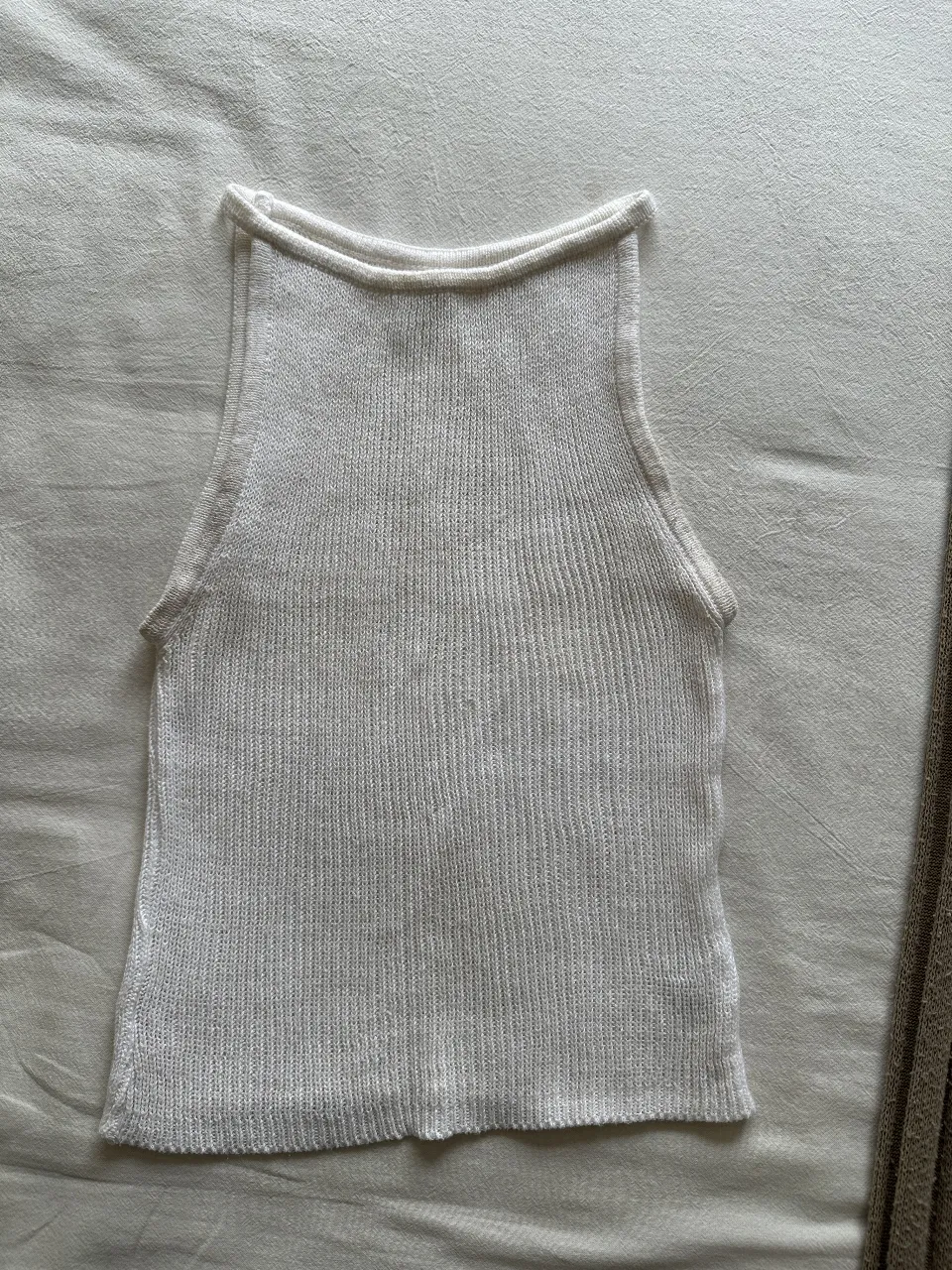 Top tejido de punto, blanco, con cuello redondo y corte recto. Ideal para un look casual y fresco.
