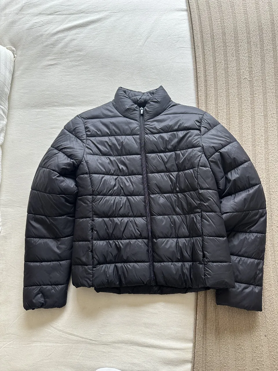 Campera de pluma negra, ideal para el invierno. Talle S, de la marca Primark Cares. Cierre frontal y cuello alto.