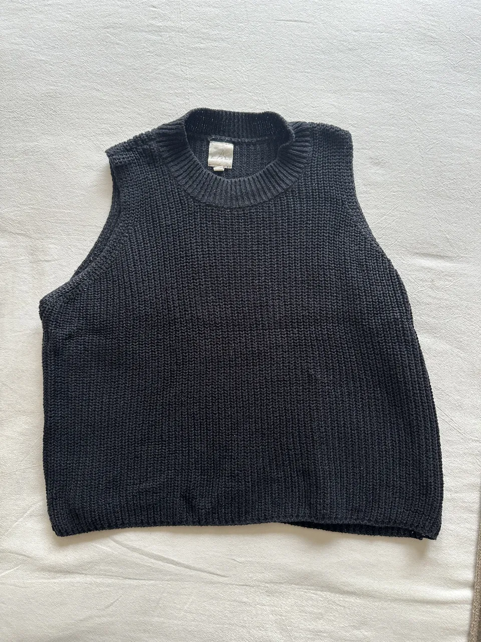Remera tejida de punto negro, sin mangas, cuello redondo. Ideal para un look casual y moderno. Talle M.
