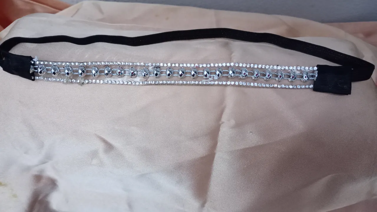Vincha elástica negra con apliques de strass plateados. Ideal para complementar un look de fiesta o evento especial.