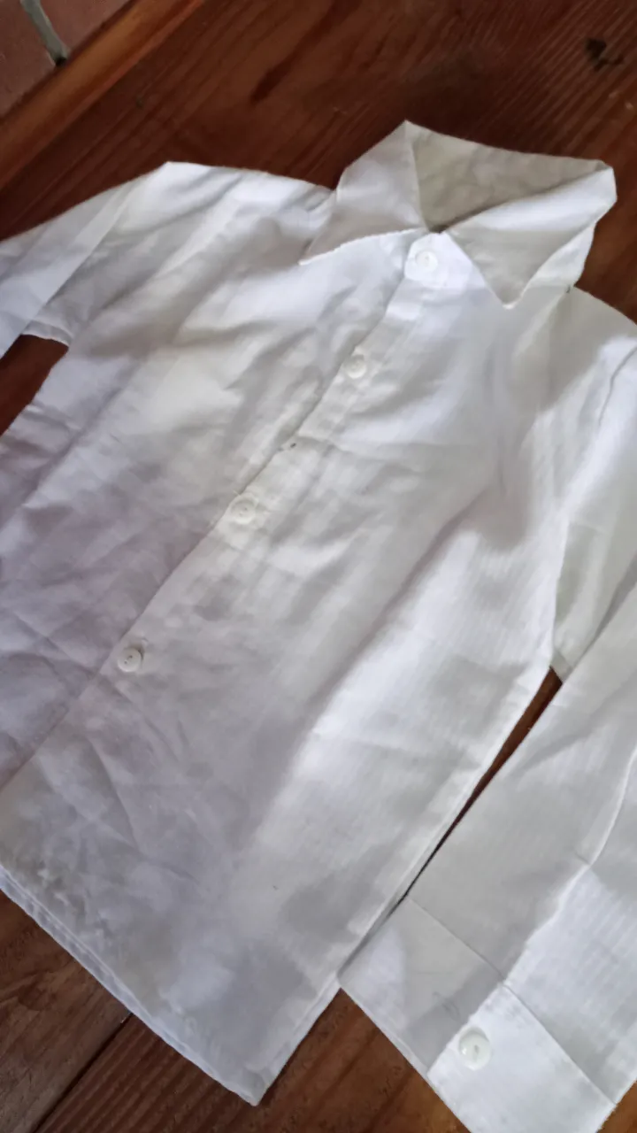 Camisa blanca de niño, manga larga, con cuello y botones. Ideal para eventos formales o para un look elegante.