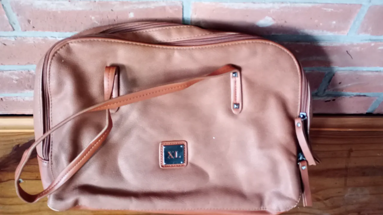 Cartera XL color marrón, ideal para escapadas y viajes. Amplio y resistente, con detalles de diseño y 3 cierres seguro. Perfecto para llevar todo lo necesario con estilo.