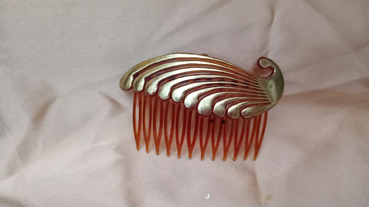Peineta dorada con diseño de hojas, ideal para complementar peinados elegantes. Perfecta para eventos especiales o para darle un toque vintage a tu look.