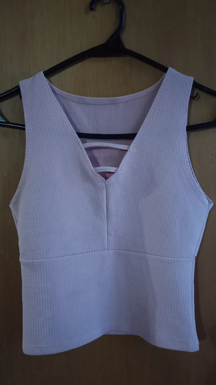 Top de mujer en color rosa claro, con escote en V y detalle de tiras en la espalda. Ideal para un look casual y moderno.