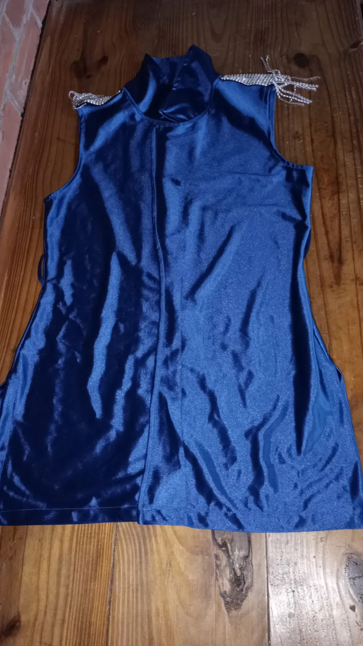 Top azul con detalles de brillos en los hombros. Cuello alto y diseño elegante para fiestas.