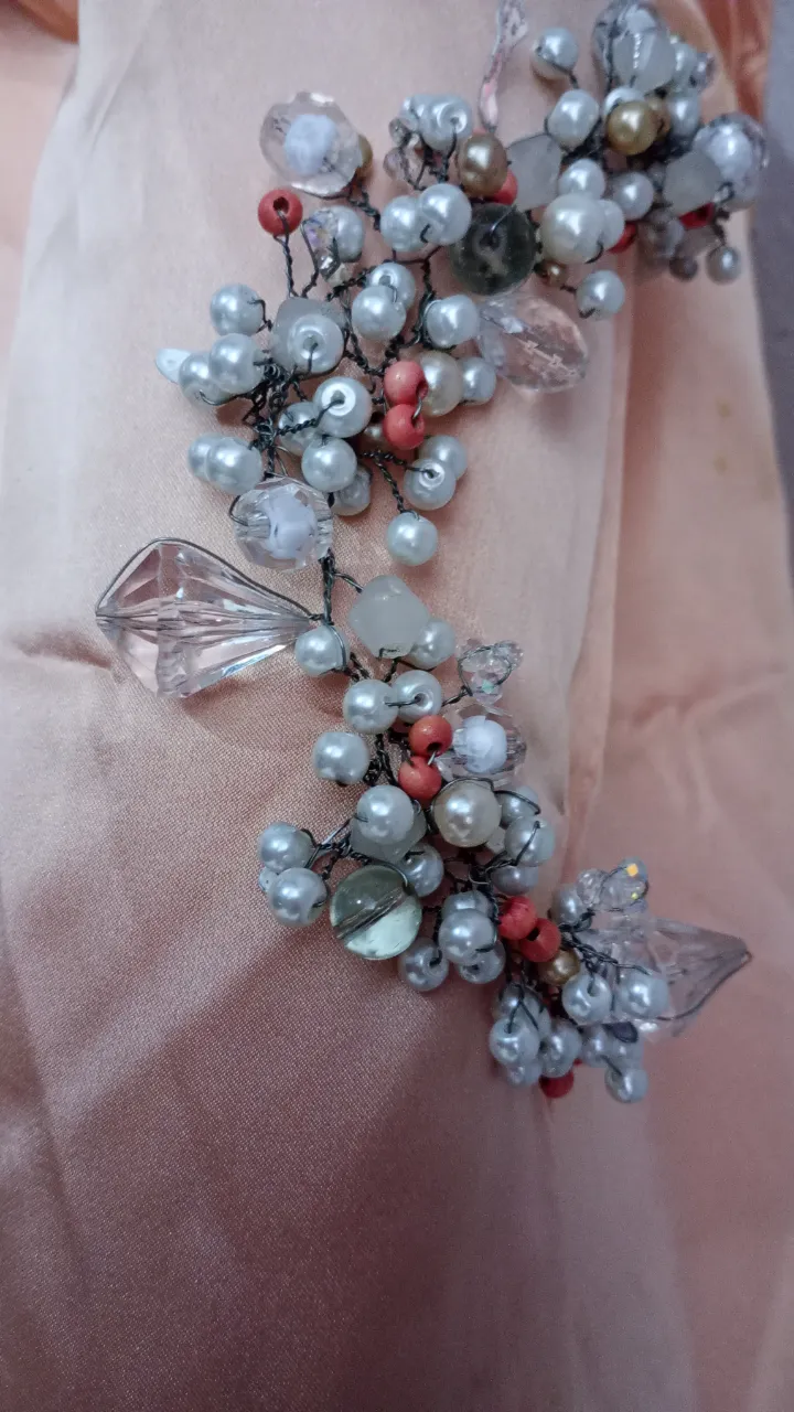 Adorno para el pelo artesanal con perlas blancas y coral, cristales y alambre plateado. Ideal para peinados de fiesta o eventos especiales.