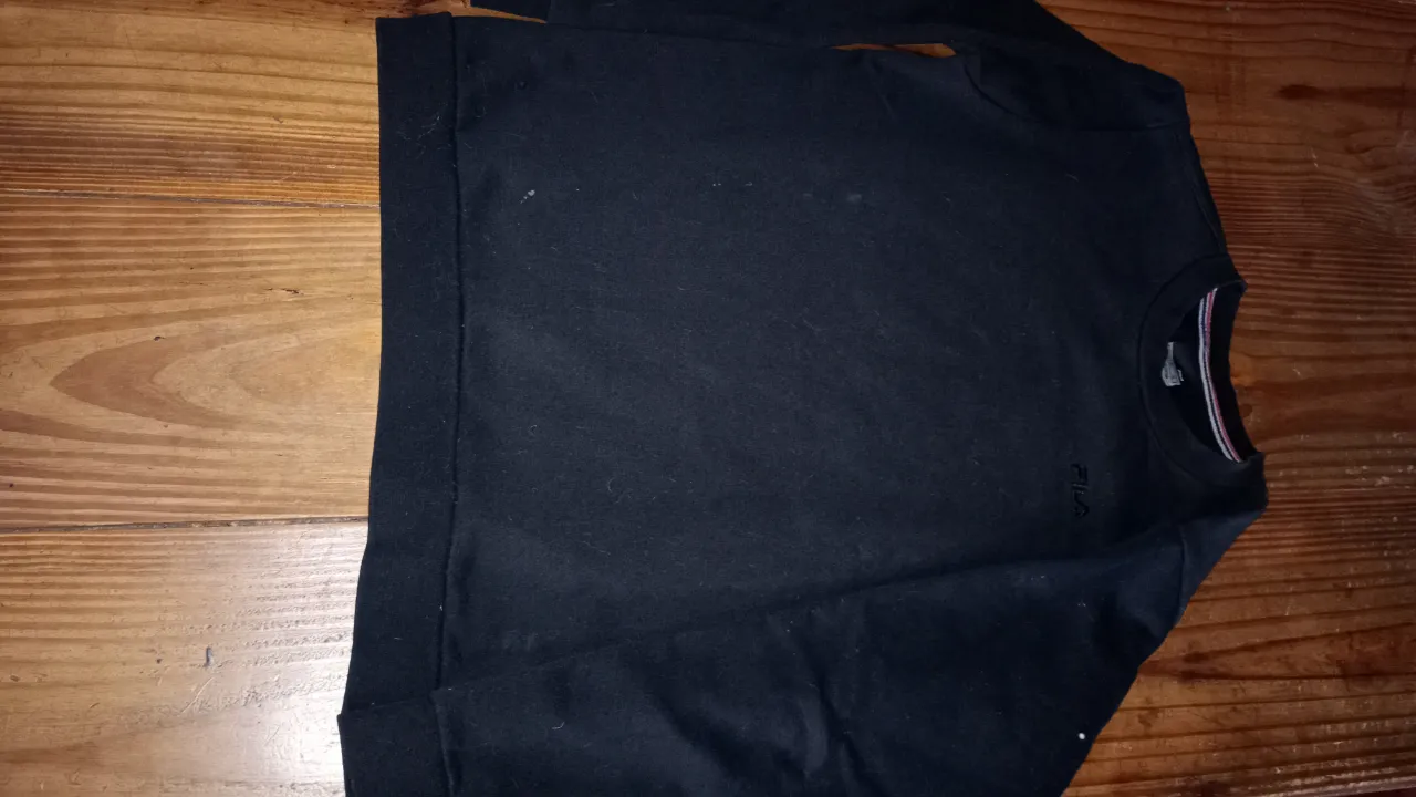 Buzo de cuello redondo negro de la marca Fila, ideal para un look casual y cómodo. Perfecto para usar en cualquier ocasión.