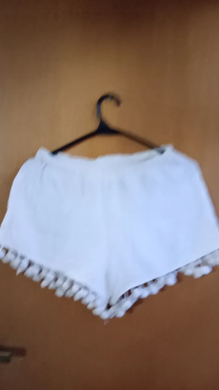 Short de mujer blanco con detalles de pompones en el borde inferior. Ideal para un look fresco y casual.