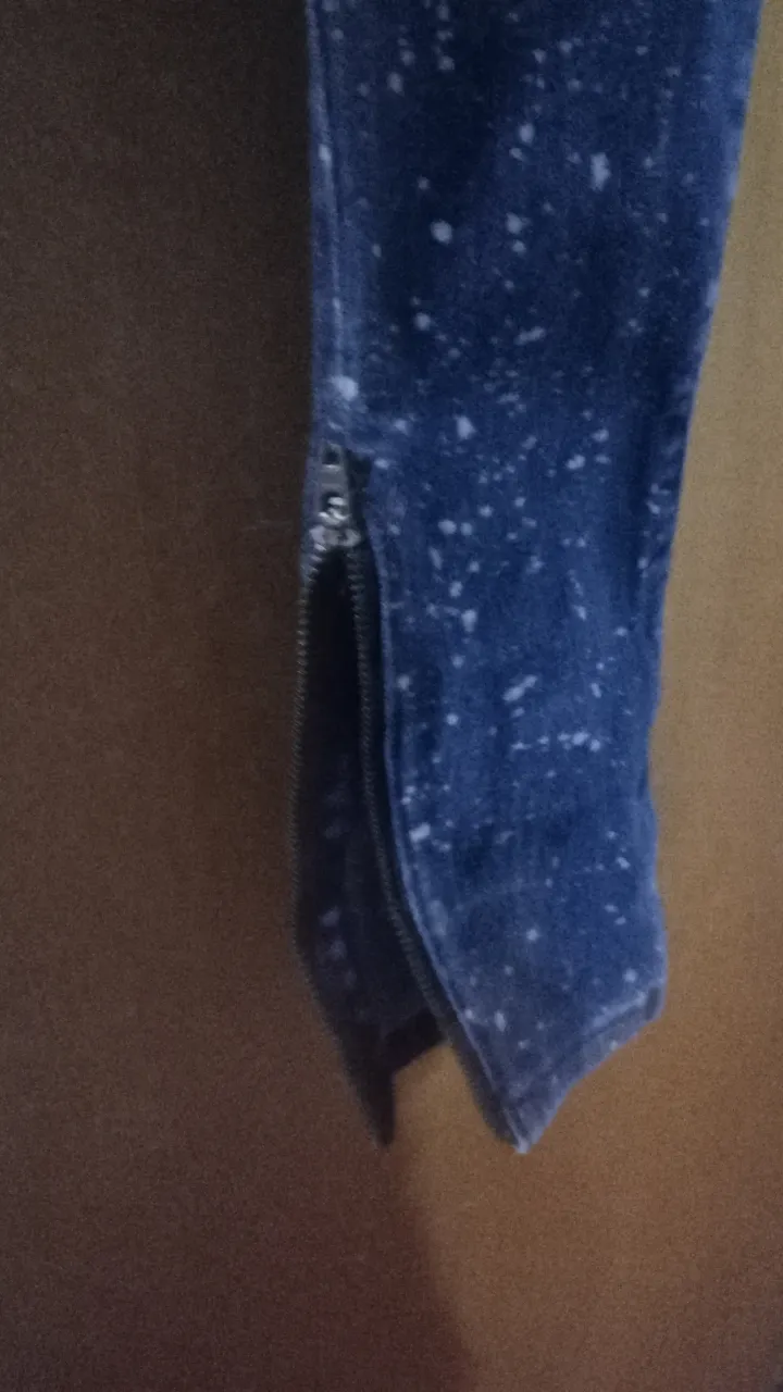 Jeans de mujer tiro alto, con detalles de salpicaduras blancas. Diseño con cierre en el tobillo para un toque moderno. Ideal para un look casual y canchero.