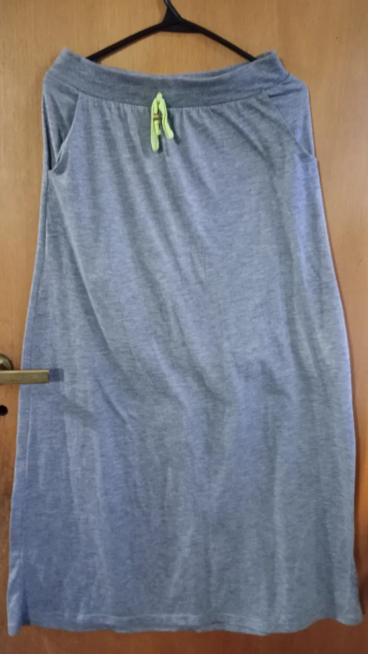 Pollera larga de mujer, color gris, con cintura elastizada y detalle de cordón amarillo. Ideal para un look casual y cómodo.