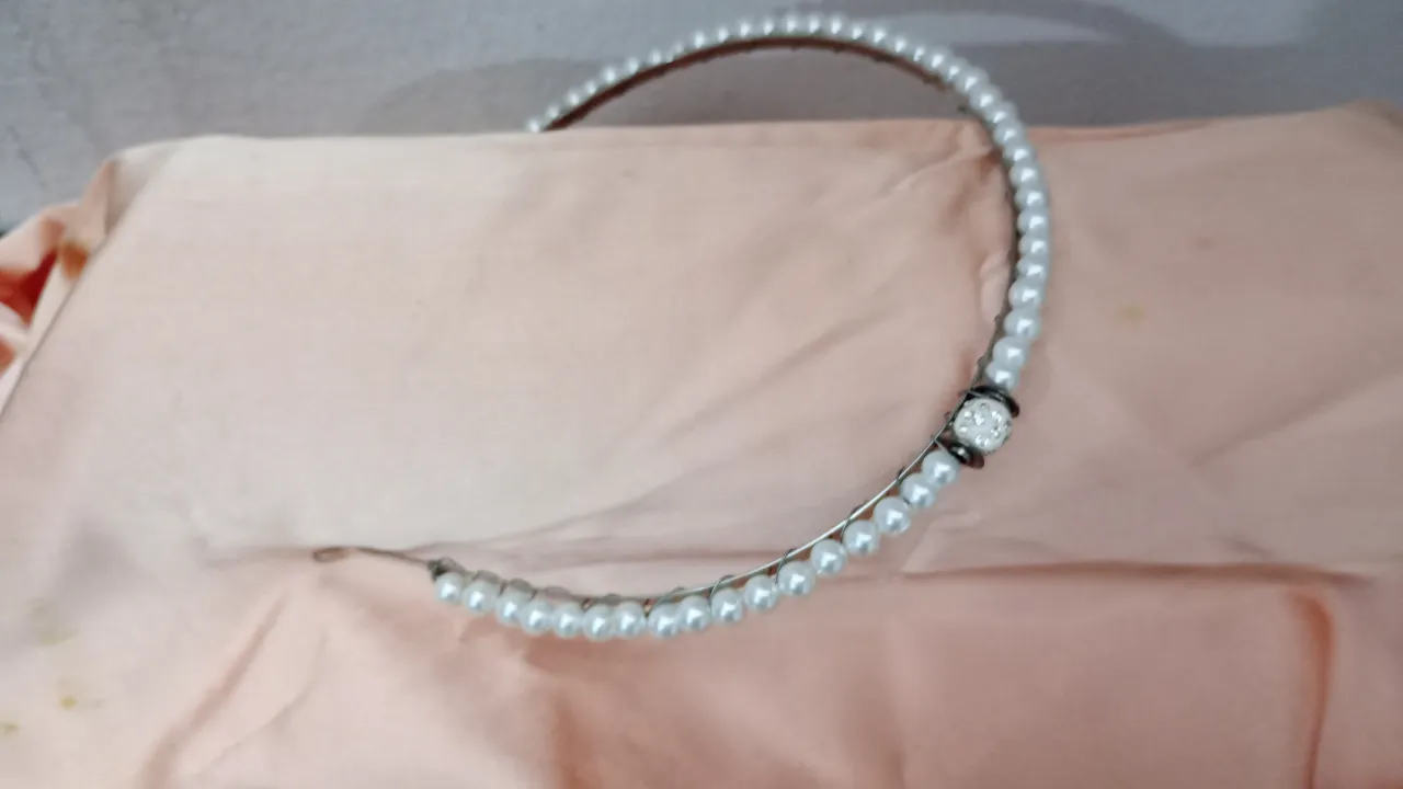 Diadema de perlas blancas con detalle de strass. Ideal para eventos especiales o para darle un toque elegante a tu look diario.