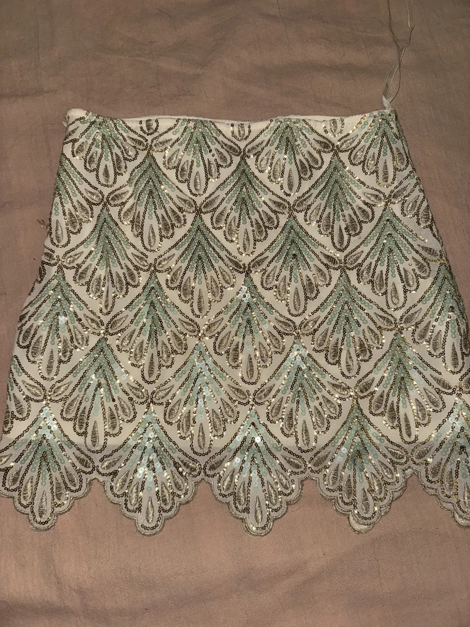 Pollera bordada corta, de fiesta, con detalles de hilo dorado y  lentejuelas doradas y verde muy claro. Diseño elegante ideal para eventos especiales. Tiro medio, con forro interior crudo. Importada, talle P (s).