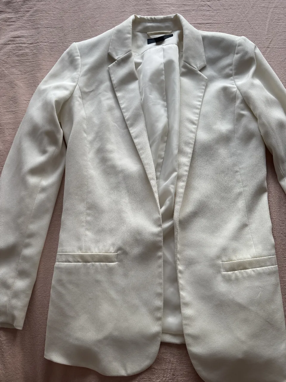 Blazer blanco de mujer, de corte clásico y elegante. Ideal para looks formales o para darle un toque sofisticado a un outfit casual. Confeccionado en una tela suave y de calidad.