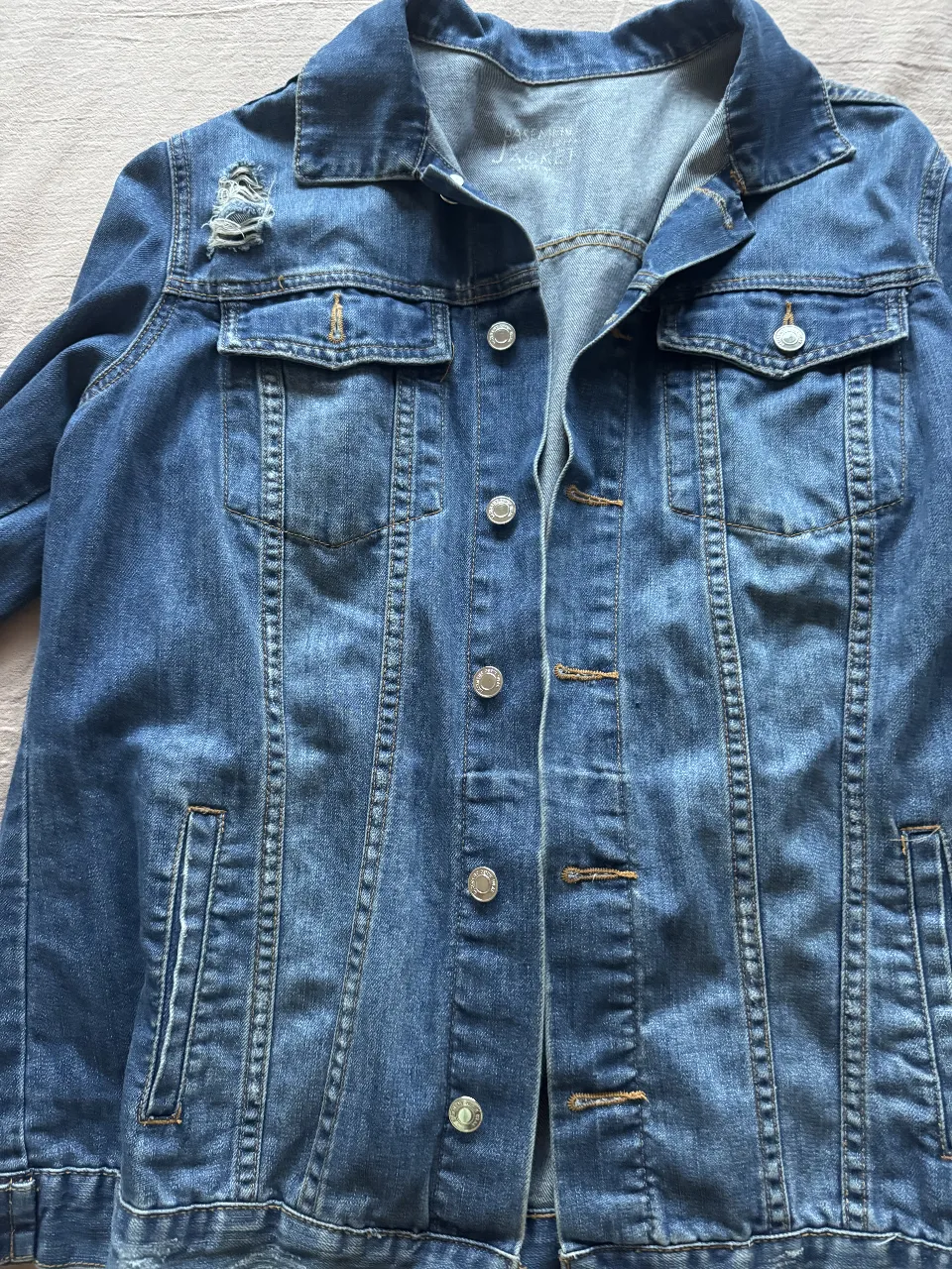 Campera de jean azul con detalles rotos, ideal para un look casual y moderno. Perfecta para usar en cualquier ocasión. Corte oversize. 